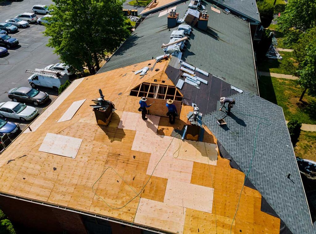 Homeowner reviews a detailed roofing proposal with a contractor beside a house and ladder.